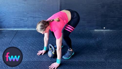 Kindal goes down into the half burpee tuck over her kettlebell.