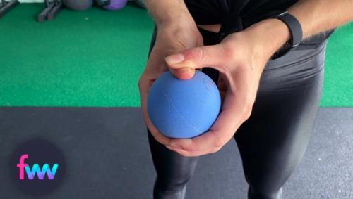 Kindal holding and pressing into the PLUS massage ball.