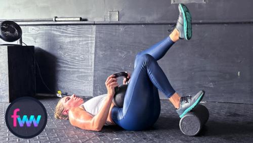 Kindal on her back with her hips on the ground and kettlebell resting on the leg that will press into the ground and into extension.