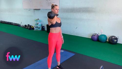 Kindal at the top of the prisoner squat with a kettlebell