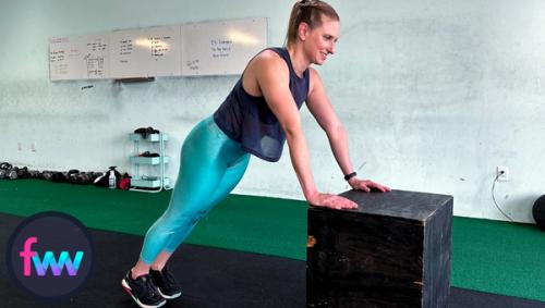 Kindal at the top of high box pushup with a tight body and arms perfectly straight.