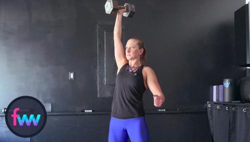 Kindal explodes with a focus on balance and uses the momentum of coming out of the squat to press the dumbbell over her head, fully extending from her shoulder.