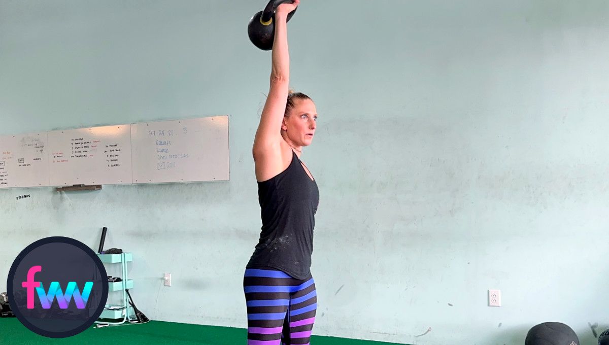 Kindal at the top of the kettlebell snatch in full extension, fully reaching up through her shoulder.