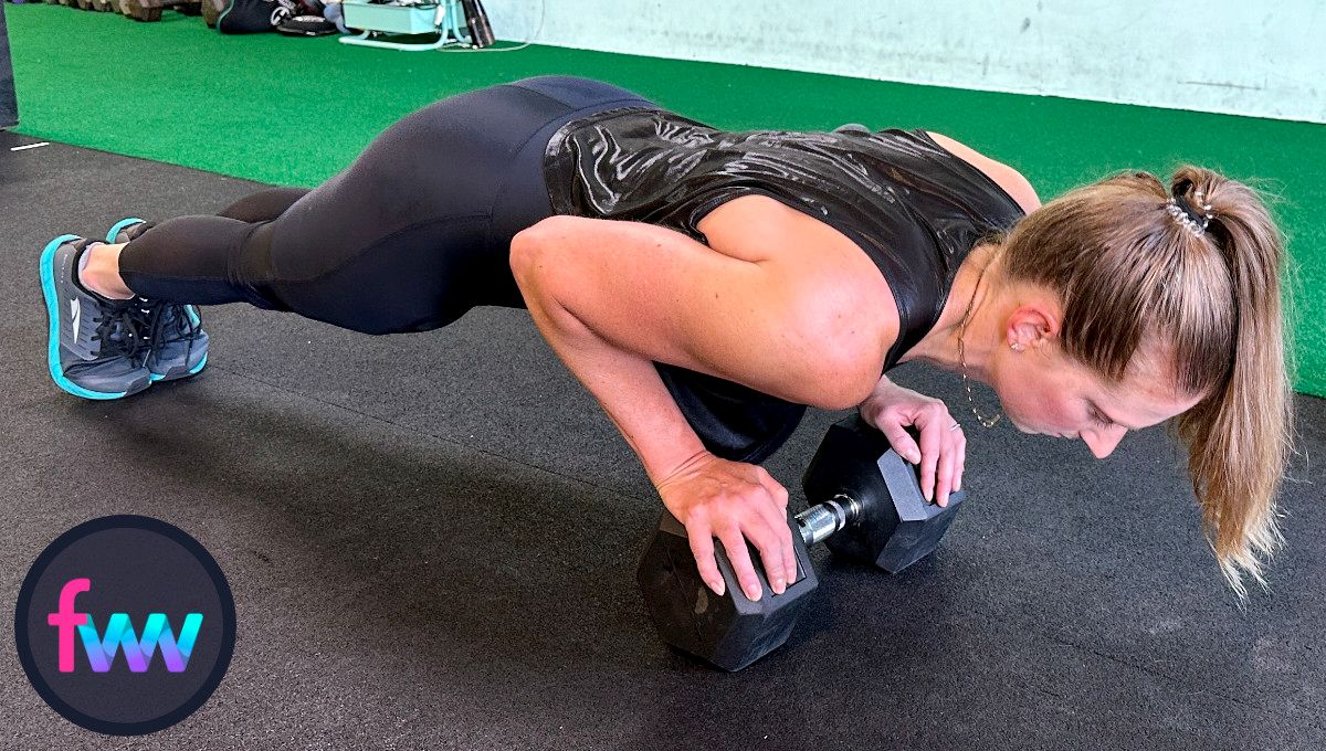 Kindal at the bottom of close grip pushups on a dumbbell. Her elbows are straight back and her body is very straight. Finally her chest is over the dumbbell and not falling backwards.