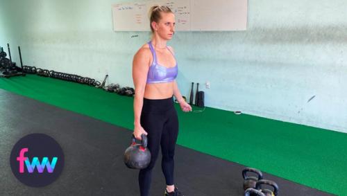 Kindal holding a heavy kettlebell at farmers carry style.