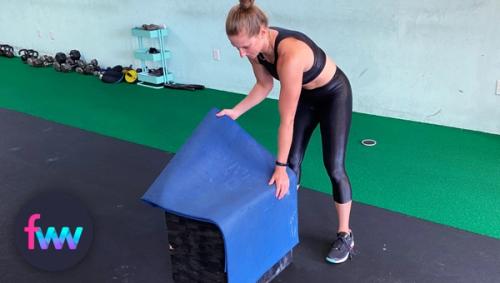 Kindal placing a mat on the box for comfort on her back.