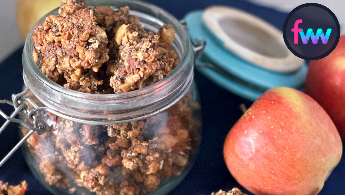 Apple granola in a jar with apples next to the jar.