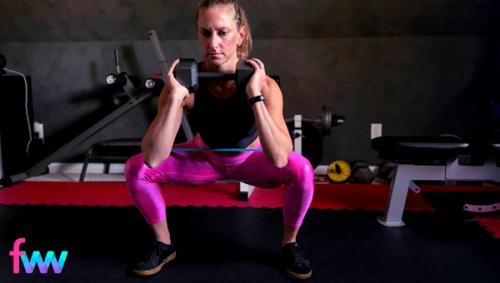 Kindal at the bottom of her squat after taking a lateral step out. She is actively pulling the band apart and twisting her feet into the ground a little more to really activate her butt muscles.