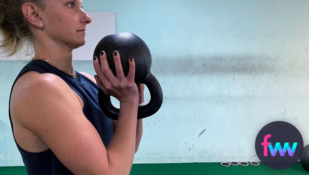 Kindal holding a kettlebell cannonball style.