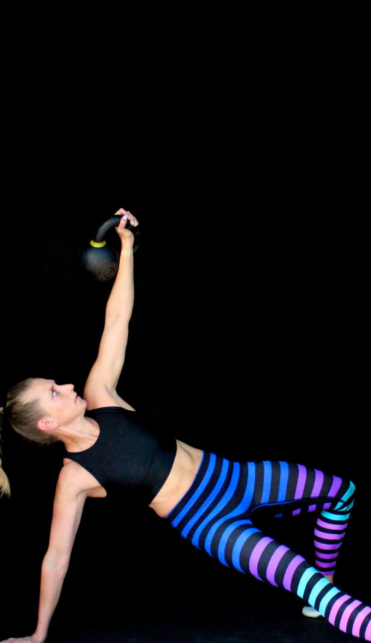 The Kettlebell Get Up Kindal halfway through doing a kettlebell get up.
