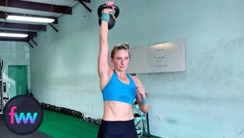 Kindal fully extending the kettlebell above her head. Overhead presses work not only strength but shoulder mobility and range of motion.