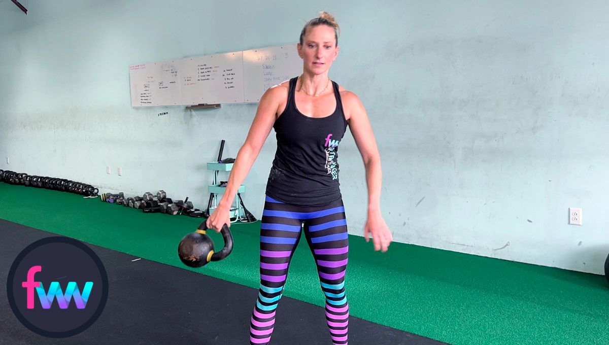 Kindal swinging the kettlebell around the side of her body and keeping her body tight. and engaged.