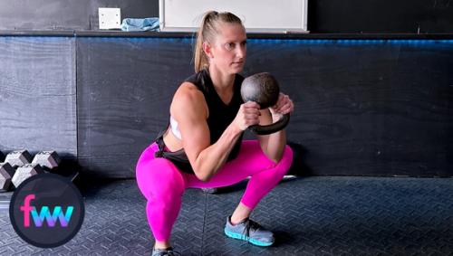 Kindal at the bottom of the squat, past parallel, and the kettlebell remains in the same position. Her balance is near perfect.