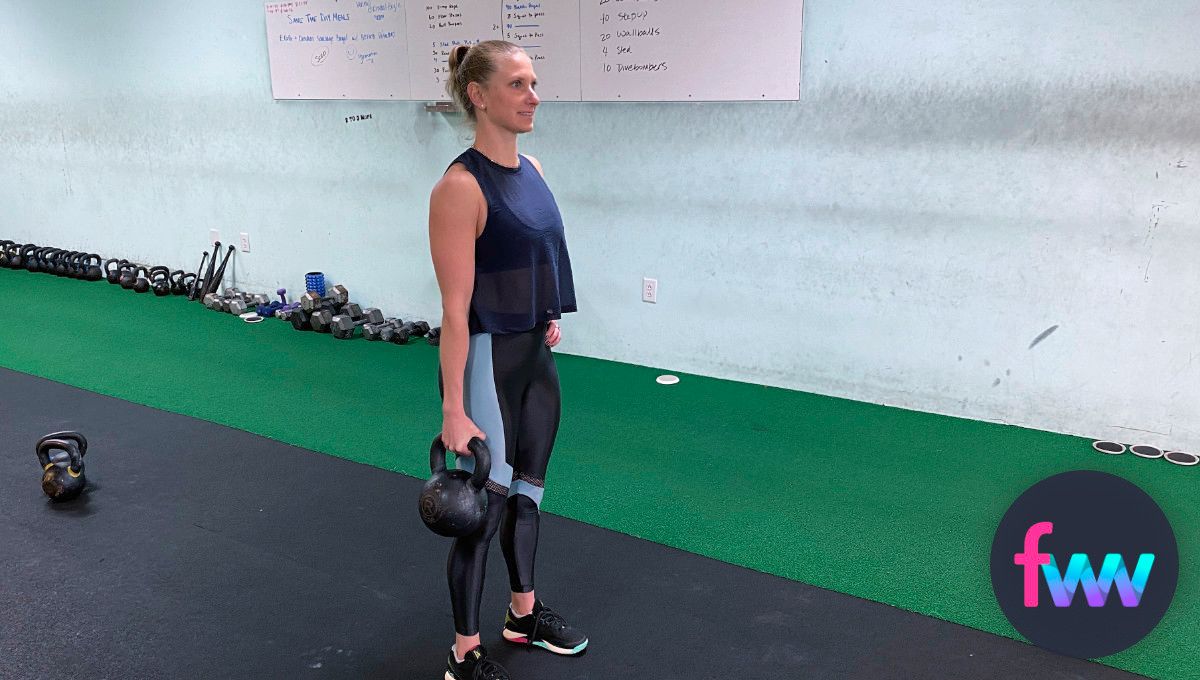 Kindal holding a kettlebell suitcase style.