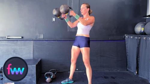 Kindal fully locked out at the top of the swing with the kettlebells at chest height.