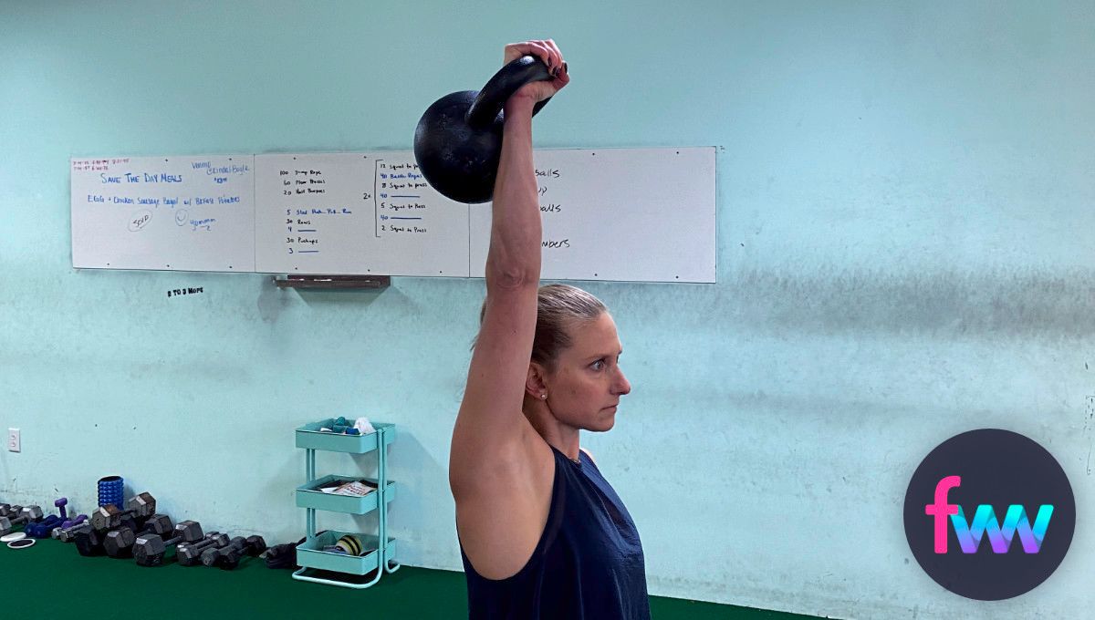 Kindal holding a kettlebell over her head.