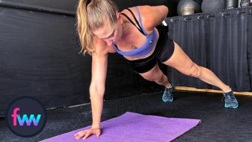 Kindal at the top of the single arm pushup with her legs wider to help give this pushup a more balance base to work from.