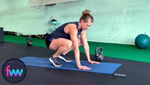 Kindal in the tucked position of the burpee getting ready to jump back into the pushup.