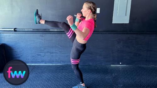 Kindal in mid-kick when doing a racked kettlebell lunge with a kick.