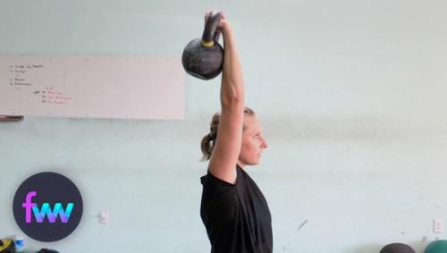 Kindal holding a kettlebell overhead with a bent wrist.