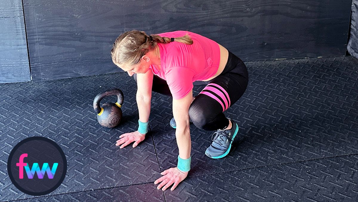 Kindal crouches down into the tuck position with her hips low and getting ready to jump back into a plank.