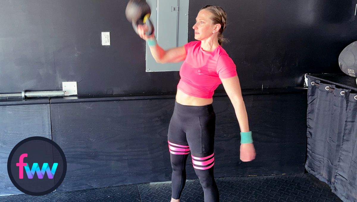 Kindal actively punches around the kettlebell so she can fully extend the kettlebell up over her head.