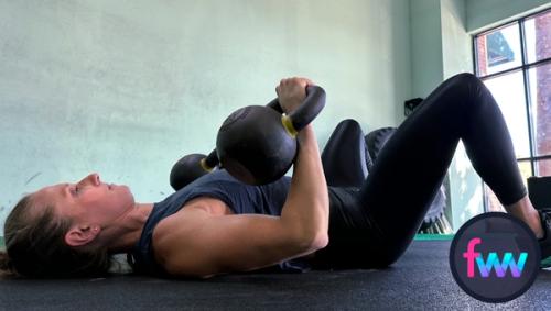 Kindal at the bottom of the double chest press. Here her elbows are just off the ground, but it's okay to let them hit the ground with control.