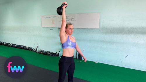 Kindal at the top of the kettlbell snatch fully extending through her shoulder.