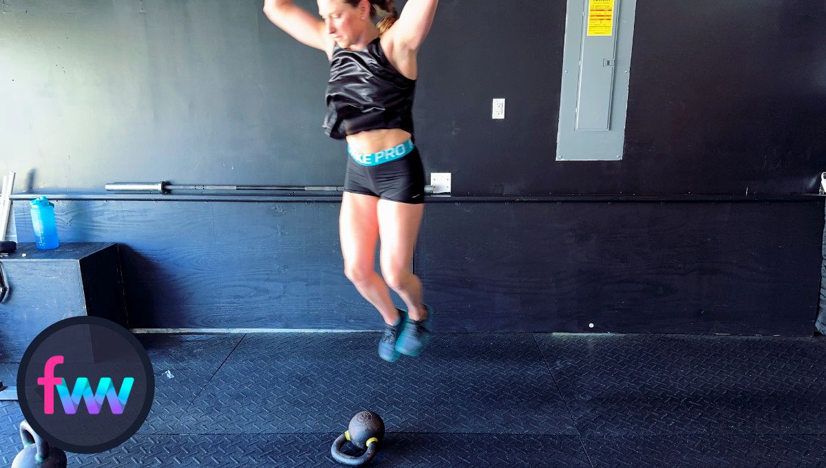 Kindal making her lateral burpee jump over the kettlebell and making sure she can complete the jump and the distance.