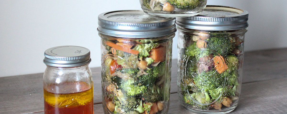 Broccoli Salad in a Jar Three stacked jars of broccoli salad marinating in a vinaigrette dressing
