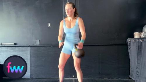 Kindal stands up with power getting the kettlebell moving around her body with some speed.