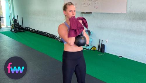 Kindal at the top of the kettlebell curl with a towel.