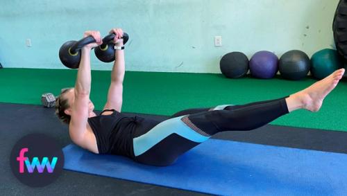 Kindal at the top of the double kettlebell hollow floor press.