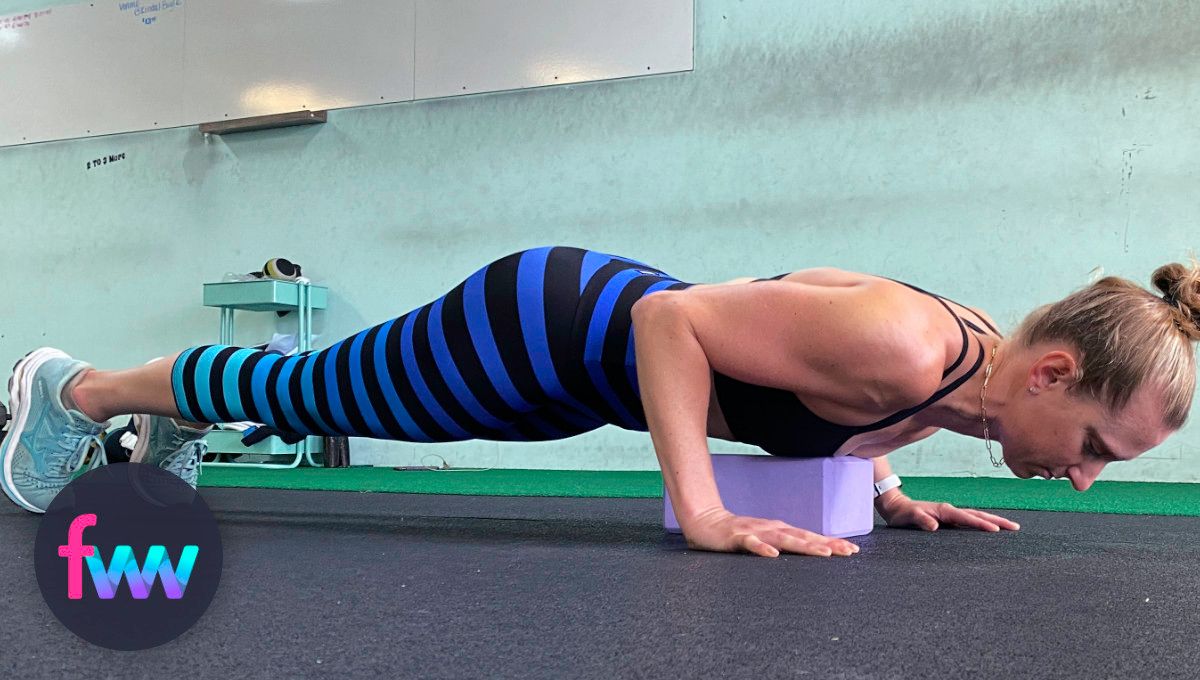 Kindal at the bottom of her pushup over the yoga block.