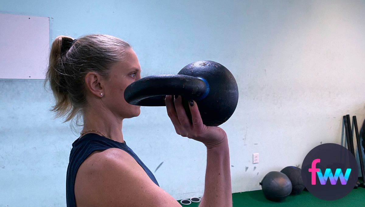 Kindal holding a kettlebell in her palm.