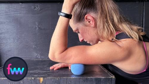 Kindal using the trigger ball to smash at the base of her tricep muscle where the blood flow is still sparse so she can increase it.