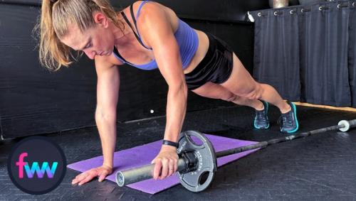 Kindal at the top of barbell concentration pushups with her hand on the barbell ready to roll out. Body is fully engaged and tight.