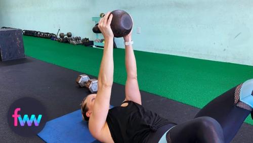 Kindal showing the top of the single kettlebell floor press.