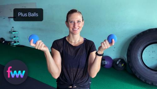 Kindal holding up the two PLUS balls outside of their tote bag.