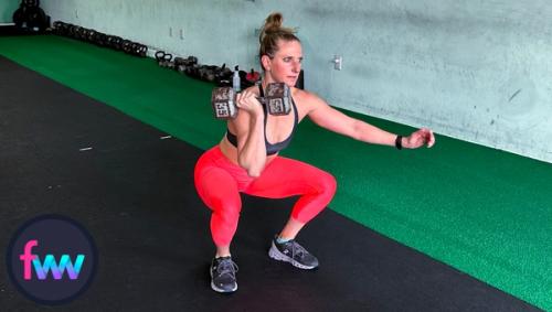 Kindal at the bottom of the dumbbell racked squat with her body fully engaged and ready to fire up.