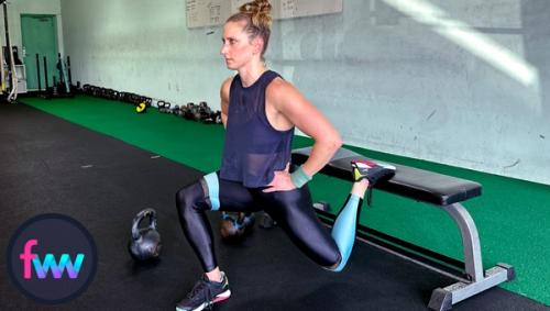 Kindal at the bottom of the bodyweight split squat with her back knee nearly touching the ground and her front knee pushed to the outside of her foot.