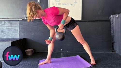 Kindal pulling the weight to the top of the row. She presses into her thigh and pulls the weight to just below her chest muscle.