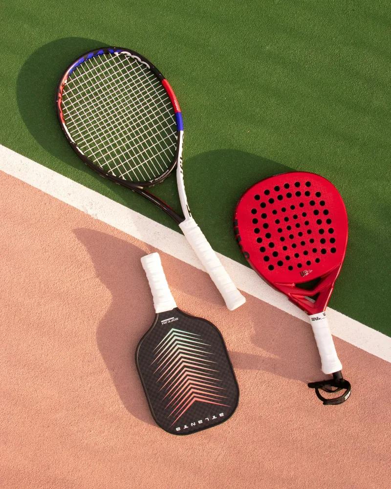 Rackets for different sports laid out on a court