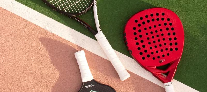 Rackets for different sports laid out on a court