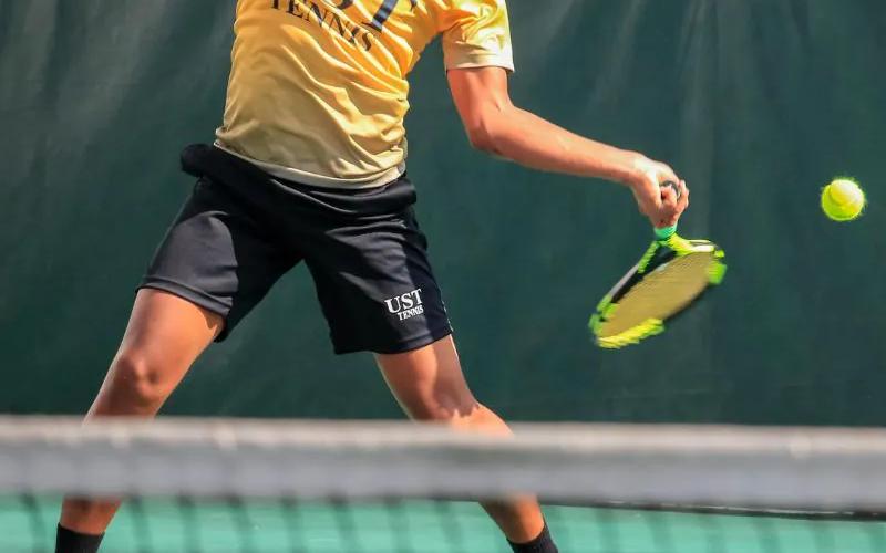 A tennis player preparing for practice on court