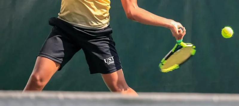 A tennis player preparing for practice on court