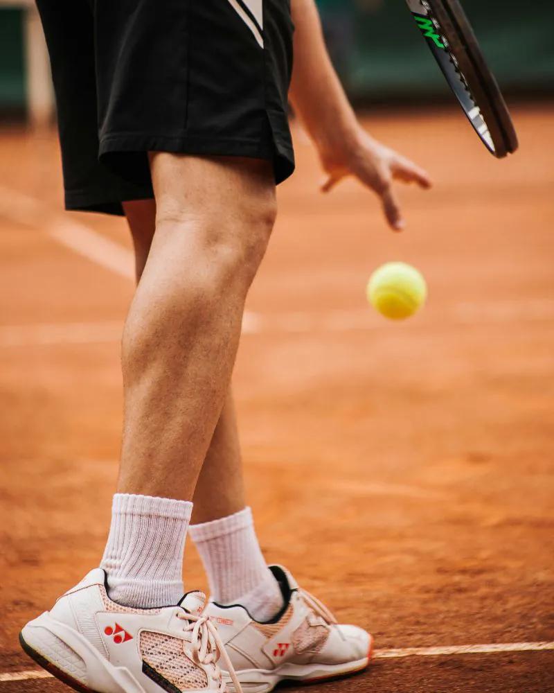 A tennis player practising on court