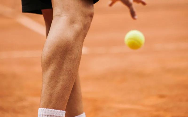 A tennis player practising on court