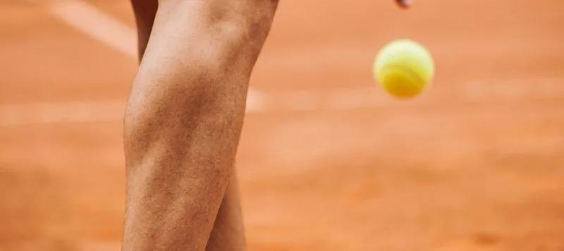 A tennis player practising on court