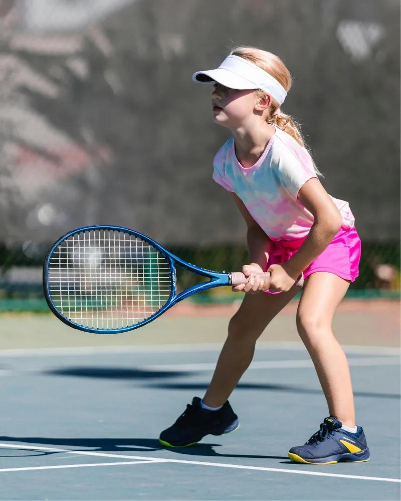 A young tennis player holding a racket on court